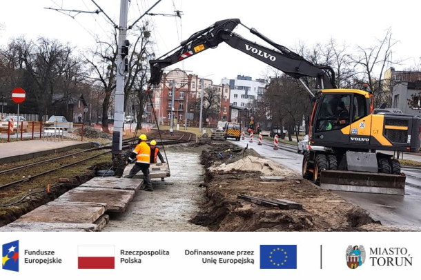 Remont torowiska - dźwig i robotnicy układający płytę torową